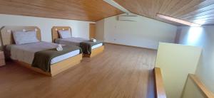 two beds in a large room with wood floors at Mansion with Swimming Pool, Pool Table & GrillArea in Braga +39 photos