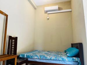 a small room with a bed and a air conditioner at Akkaraipattu Guest House in Akkaraipattu