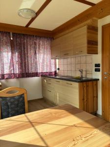 a kitchen with wooden cabinets and a wooden table at Appartamenti la Fontana in San Martino in Badia +25 photos