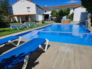 a blue swimming pool with chairs and a house at Lavanda Natur León3 Apartment 5 Pers in Villafañé