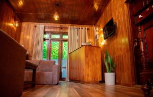 a living room with wood paneling and a couch and a television at Zenora Villa ella in Ella
