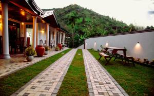 a garden with a brick walkway next to a building at Zenora Villa ella in Ella