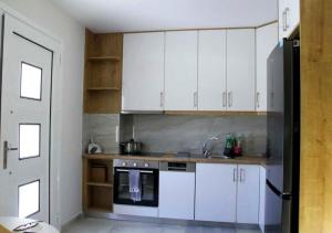 a kitchen with white cabinets and a sink at Thaleia apartment in Igoumenitsa +3 photos