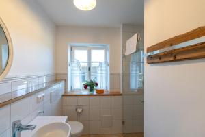 ein Badezimmer mit Toilette, Fenster und Waschbecken in der Unterkunft Lisbeth in Rottenbuch + 37 Fotos
