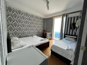 a hotel room with two beds and a window at Hotel Olimp in Shekhvetili