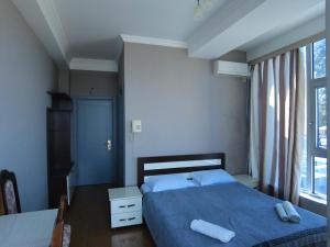 a bedroom with a blue bed and a window at Hotel Olimp in Shekhvetili
