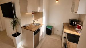 a small kitchen with a sink and a counter at Apartament Okrzei in Lublin +2 photos