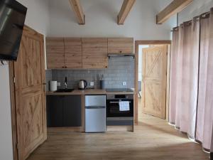 a kitchen with wooden cabinets and a stove top oven at Bieszczady Bóbrka 24 in Bóbrka