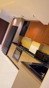 a kitchen with wooden cabinets and a counter top at Ayden Residence Béjaïa in Bejaïa +11 photos