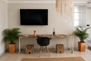 a table with a black chair and a television on a wall at Casa Elixir Boutique in Barranquilla