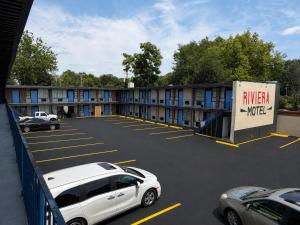 a parking lot with a white car parked in it at Riviera motel in Detroit