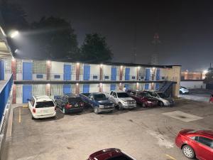 a parking lot with cars parked in front of a building at Riviera motel in Detroit