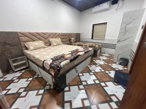 a bedroom with a bed in the middle of a room at Shreeji Nikunjdham in Vrindāvan