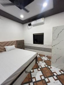 a room with a bed and a flat screen tv at Shreeji Nikunjdham in Vrindāvan