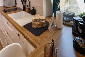 a kitchen counter with a sink and a basket on it at Duplex Sauna Cinéma in Riom +17 photos