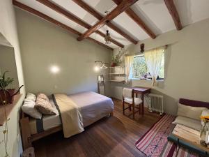 a bedroom with a bed and a table in a room at Cosy Private Room In A Community Home - A Space To Remember You In Andean Mountains in Pisac