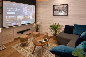 a living room with a couch and a flat screen tv at Duplex Sauna Cinéma in Riom