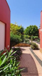 a brick walkway next to a red building at Casa Girasoles terraza patio aire acondicionado in Corralejo