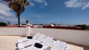 two white chairs sitting on top of a roof at Casa Girasoles terraza patio aire acondicionado in Corralejo
