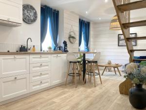 a kitchen with white cabinets and a table with chairs at Duplex Sauna Cinéma in Riom