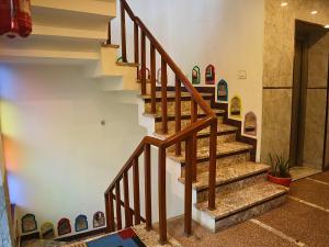 a staircase with wooden railings in a house at Jungle by sturmfrei Agra in Agra
