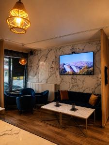 a living room with a tv on a wall at Hotel Taormina Brussels Airport in Zaventem