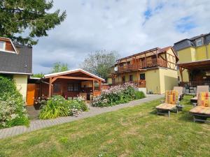 a group of buildings with a yard with benches at Pension am Elberadweg in Radebeul