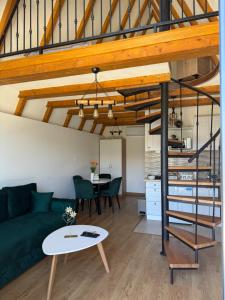 a living room with a green couch and a spiral staircase at Bungalows Panorama Hills in Plužine +60 photos