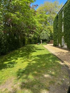 a grassy yard next to a building with trees at Scarthingmoor Lodges in Weston