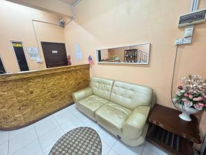 a waiting room with a couch and a mirror at Hotel RS Inn in Rantau Panjang