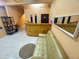 a waiting room with a leather couch and a counter at Hotel RS Inn in Rantau Panjang +73 photos