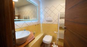 ein Badezimmer mit Waschbecken, Toilette und Spiegel in der Unterkunft Residence Sciara Sciat in Foggia