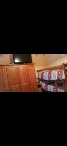 ein Schlafzimmer mit zwei Etagenbetten und Holzschränken in der Unterkunft Chalet Laghetti in Schilpario