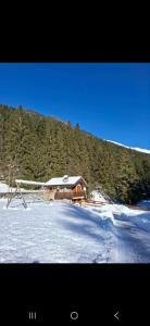 ein Haus im Schnee vor einem Berg in der Unterkunft Chalet Laghetti in Schilpario + 3 Fotos