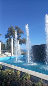 two water fountains in a swimming pool at SeaSuites Artemida in Artemida