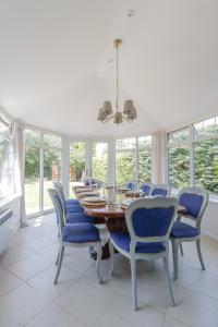 a dining room with a wooden table and blue chairs at Stylish Cheshire House in Winsford