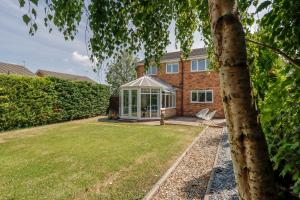 a house with a glass greenhouse in the yard at Stylish Cheshire House in Winsford