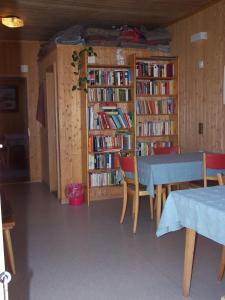 ein Esszimmer mit einem Tisch und einem Bücherregal mit Büchern in der Unterkunft Bärghuus Axalp in Axalp