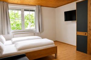 two beds in a room with a window at Appartmenthaus Rosenhof in Podersdorf am See