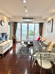a living room with a couch and a table and chairs at Amazing Spacious Seaview Condo in North Pattaya
