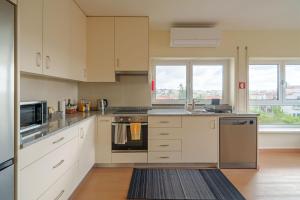 a kitchen with white cabinets and stainless steel appliances at StaynFeel 04 in Fátima