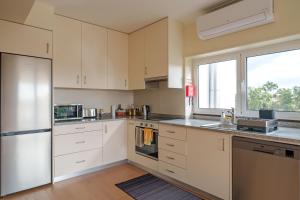 a kitchen with white cabinets and a large window at StaynFeel 04 in Fátima