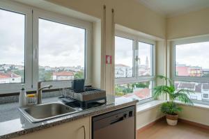 a kitchen with windows and a sink and a counter at StaynFeel 04 in Fátima