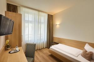 a hotel room with a bed and a tv at City Partner Hotel Berliner Hof in Karlsruhe