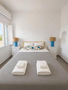 a bedroom with a large bed with towels on it at Orama Suite II Mykonos Sunset & Pool in Mikonos +7 photos