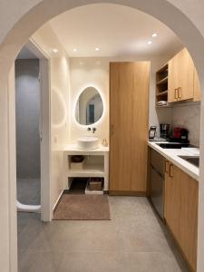 a bathroom with a sink and a counter with a mirror at Orama Suite II Mykonos Sunset & Pool in Mikonos