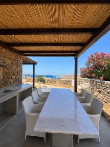 a table and chairs on a patio with a view of the ocean at Orama Suite II Mykonos Sunset & Pool in Mikonos