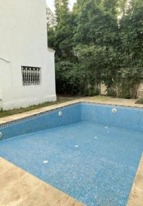 a blue swimming pool in a yard with a building at Villa Yassir expert Cabo in Cabo Negro