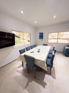 a dining room with a white table and blue chairs at Villa Yassir expert Cabo in Cabo Negro