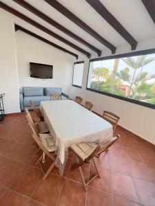 a dining room with a table and chairs and a couch at Villa Yassir expert Cabo in Cabo Negro +4 photos